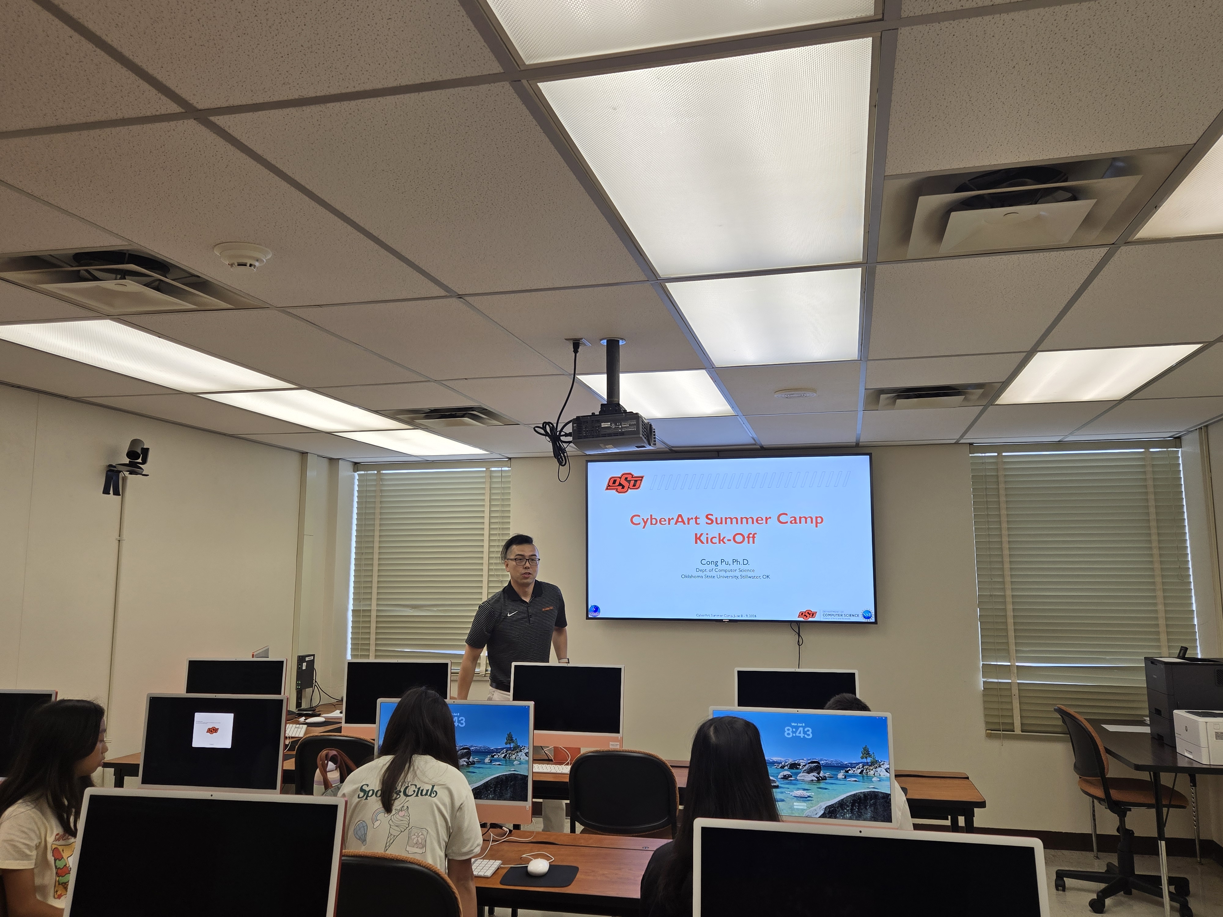 A professor stands at the front of a classroom teaching students.
