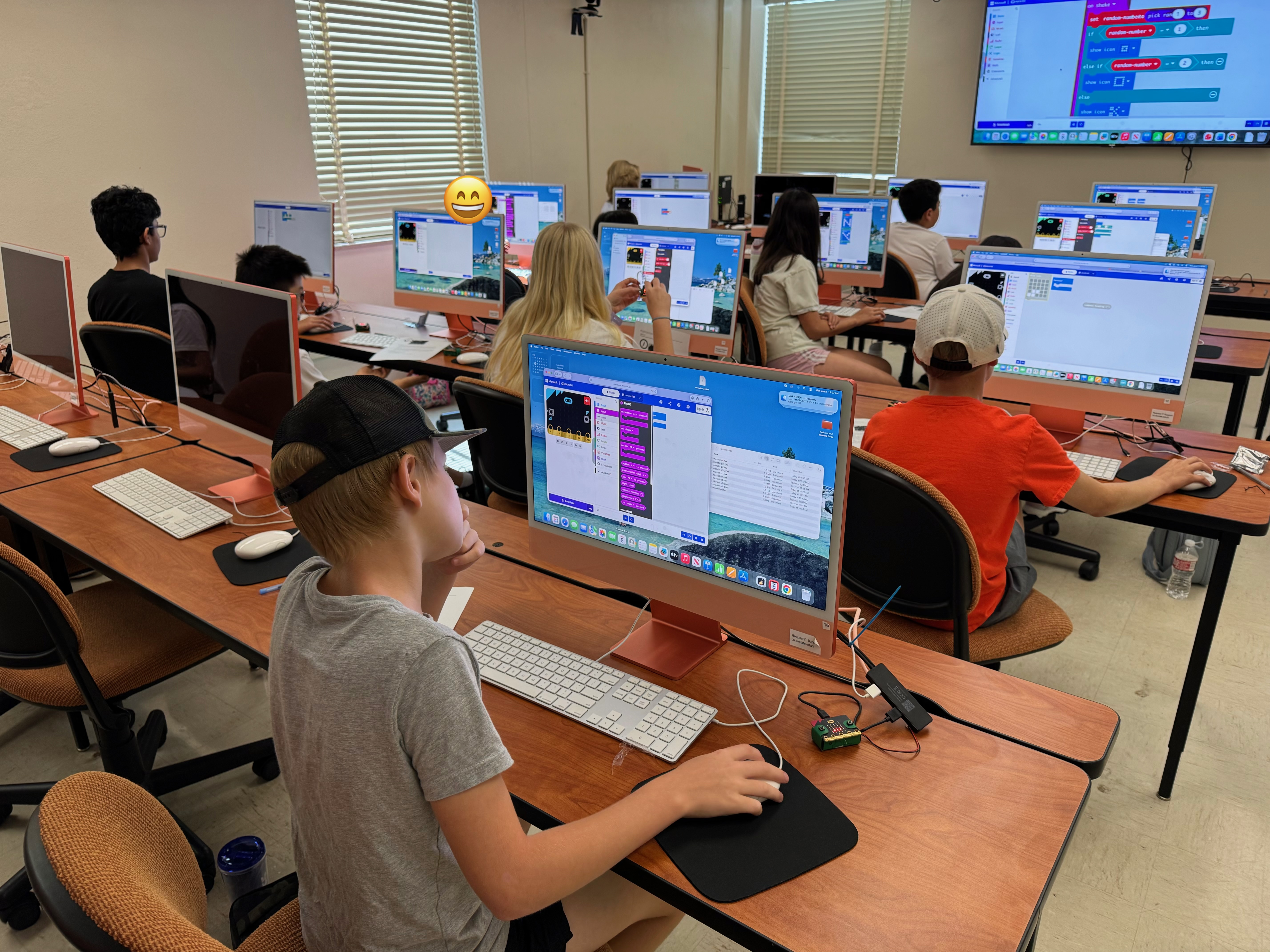 Students working at desktop computers in a computer lab during class.