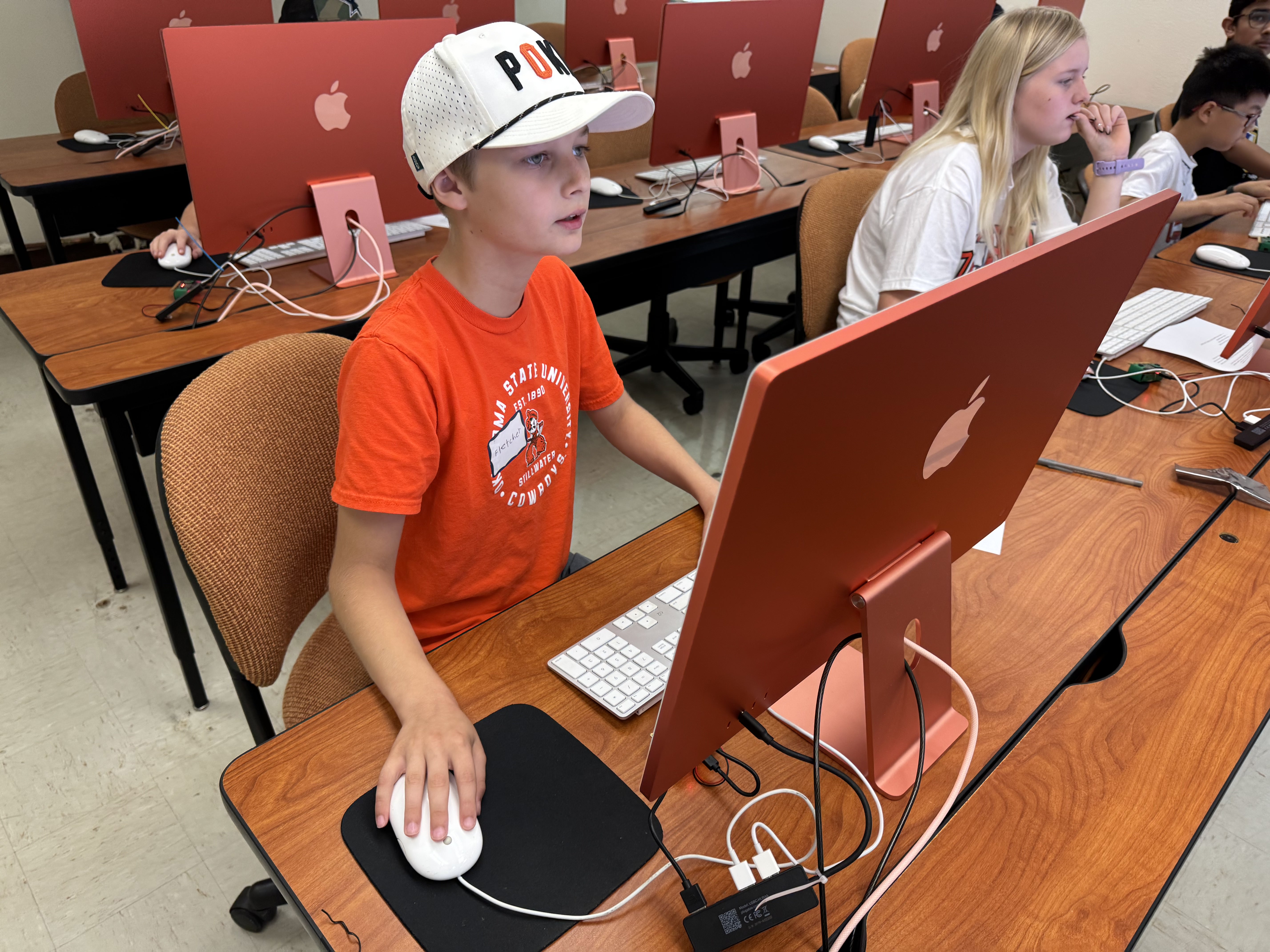 Student working at desktop computers in a computer lab during class.