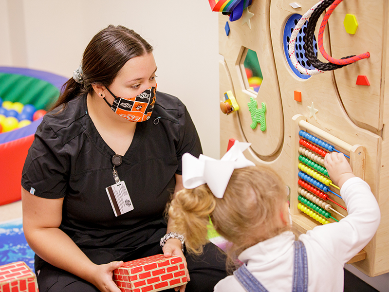 extension.jpg Female student working with a child.