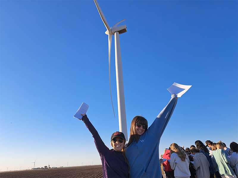 Female students on a field trip in front of a wind tower in the Gloss Mountains Female students on a field trip in front of a wind tower in the Gloss Mountains
