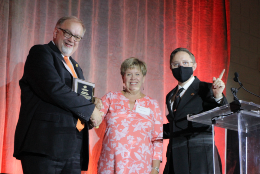 Mr. Rick Fritz, Mrs. Patty Walker and Mr. John Fields posing on stage for a group photo.