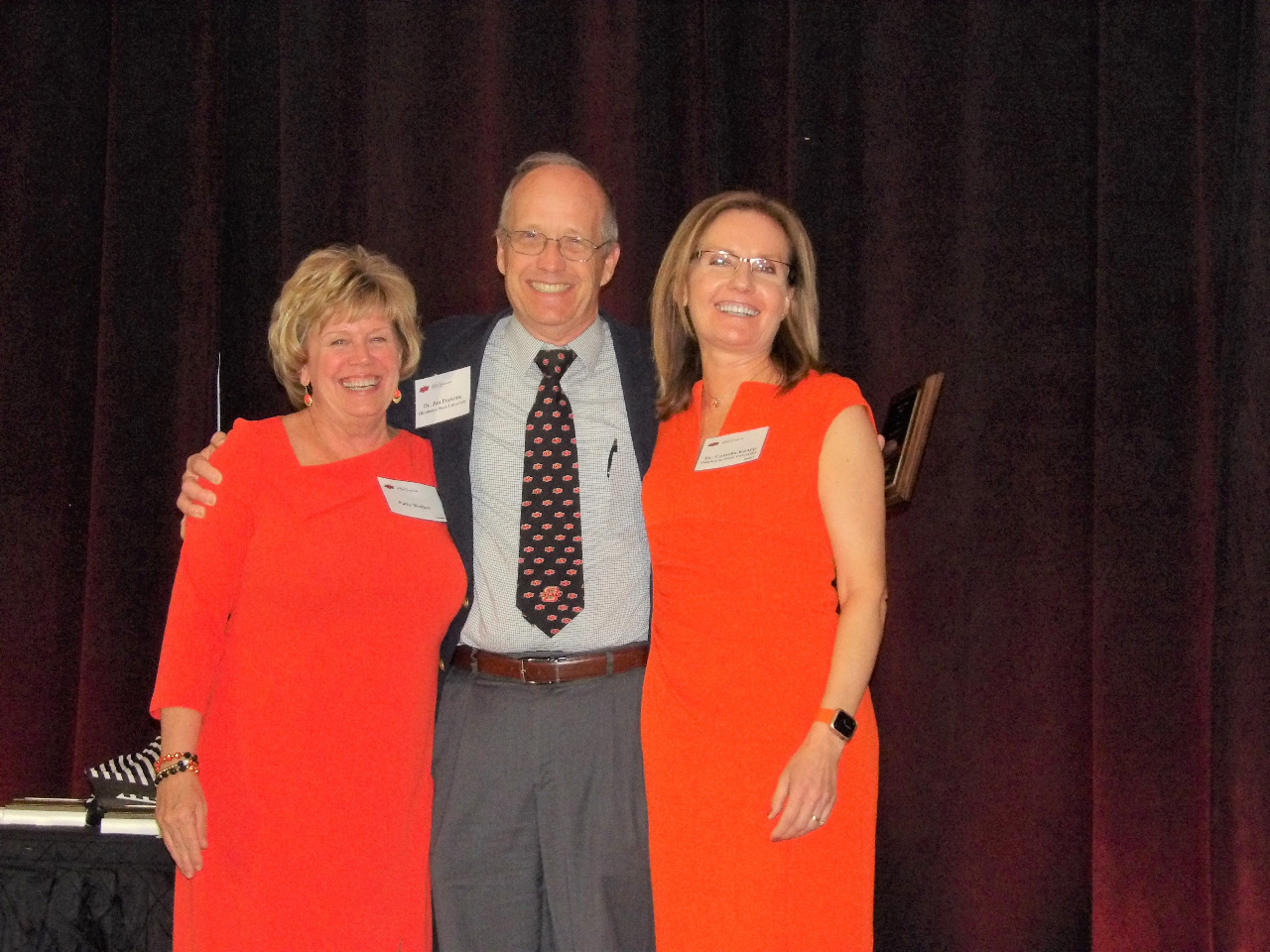 Mrs. Patty Walker and Dr. Camelia Knapp presenting and award to Dr. JIm Puckette.