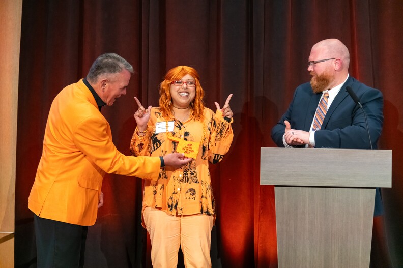 Mike Gaskins and Brandon Spencer giving Monica Hinson first place for the Rock The Orange Award.