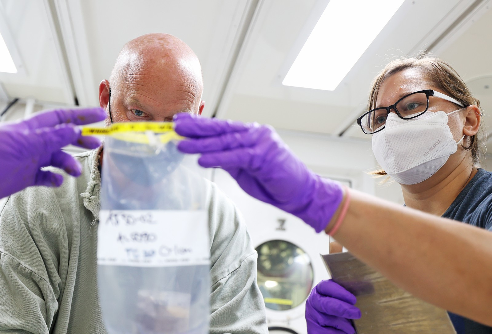 Dr. Burkett in lab with male student working with a speciman.
