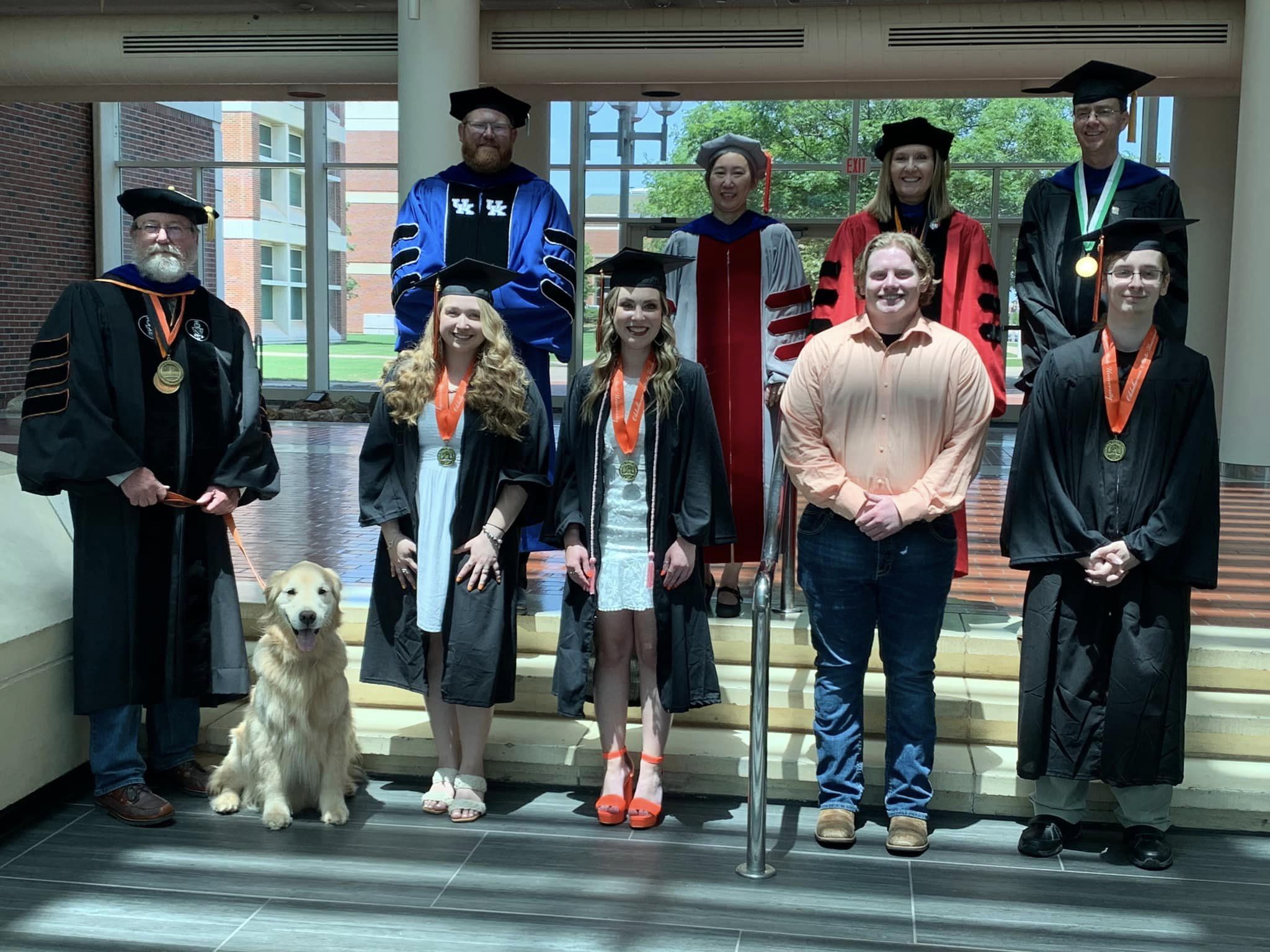 A group of garduate students with their faculty advisors in their caps and gowns.