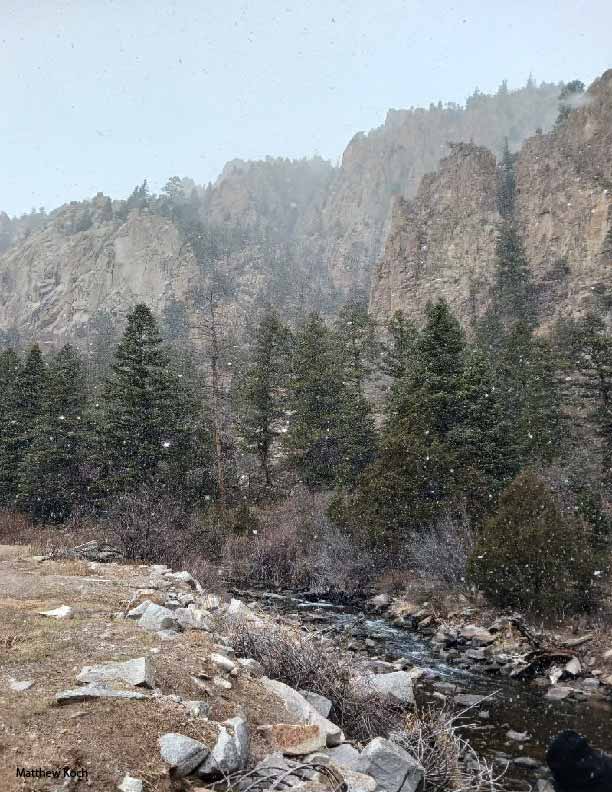 Snow falling on river bend in Red River New Mexico.