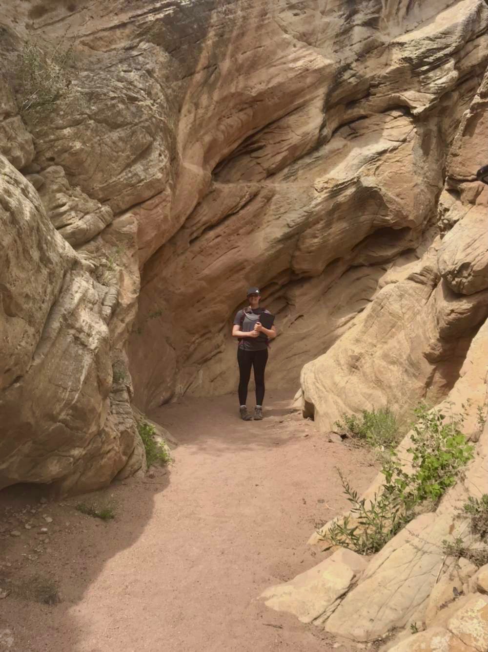 Student Chaira standing down a trail surrounded by rock formations. Student Chaira standing down a trail surrounded by rock formations..