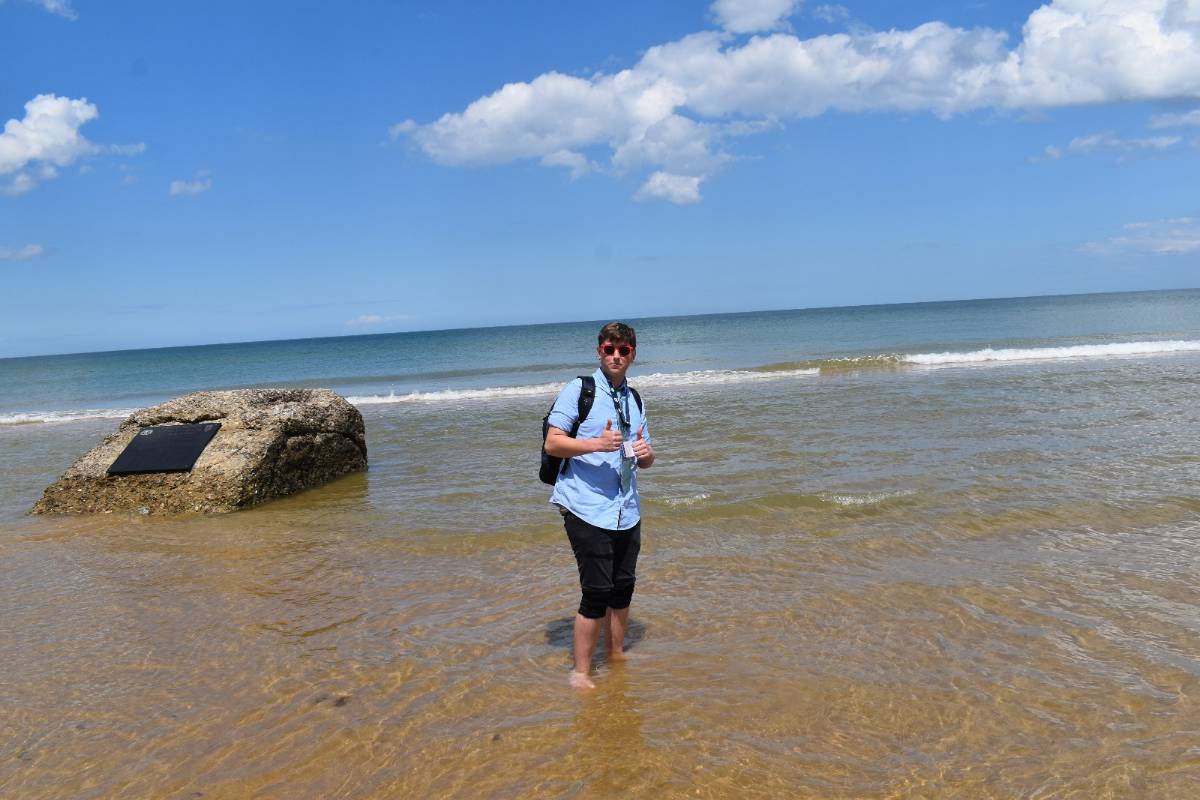 Student standing on the beach 