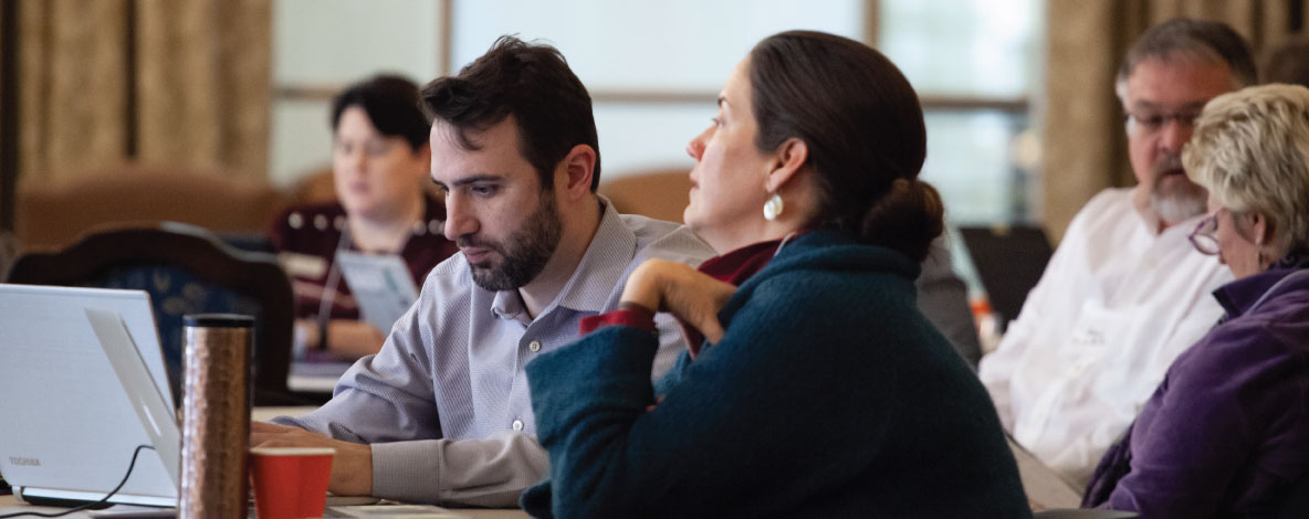 dhi_page.jpg Digital Humanities, 5 people seated at tables working at laptops on large wooden desks