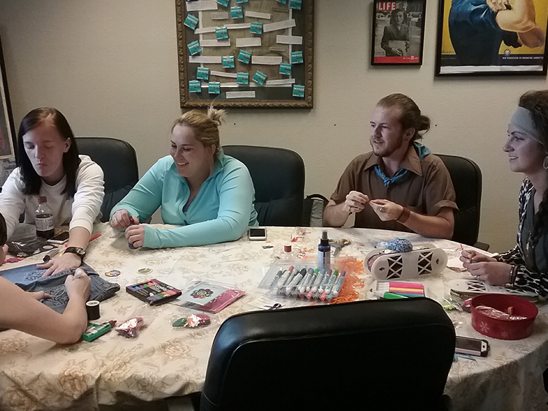 Group of student sitting around a table working on a project Group of student sitting around a table working on a project
