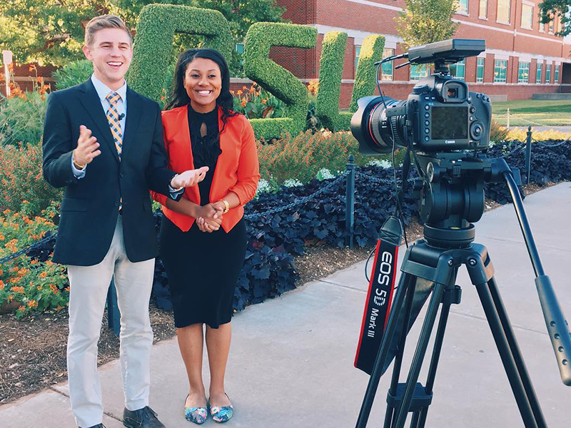 Male and female student reporting in front of a camera Male and female student reporting in front of a camera