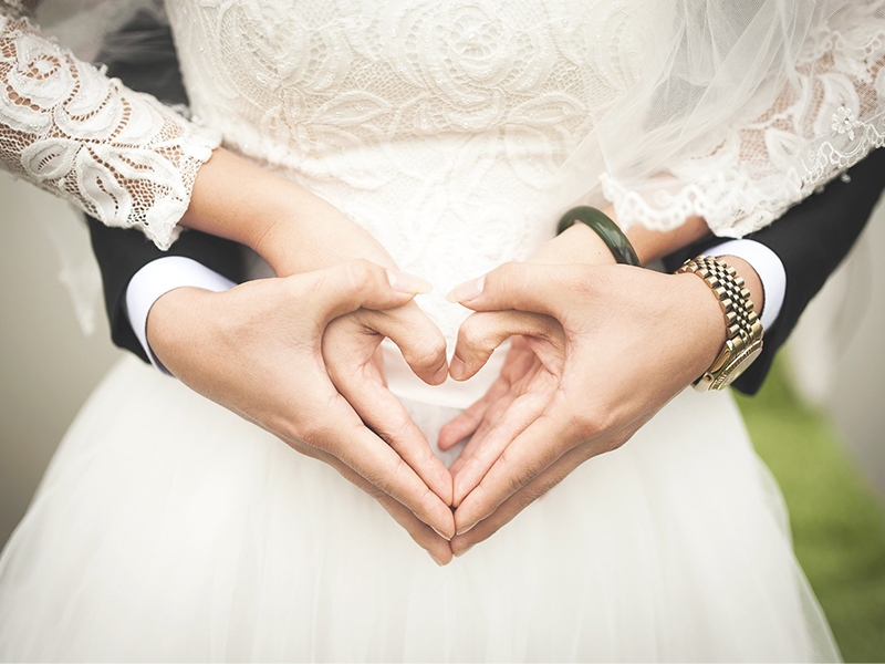 just married couple holding hands in heart shape