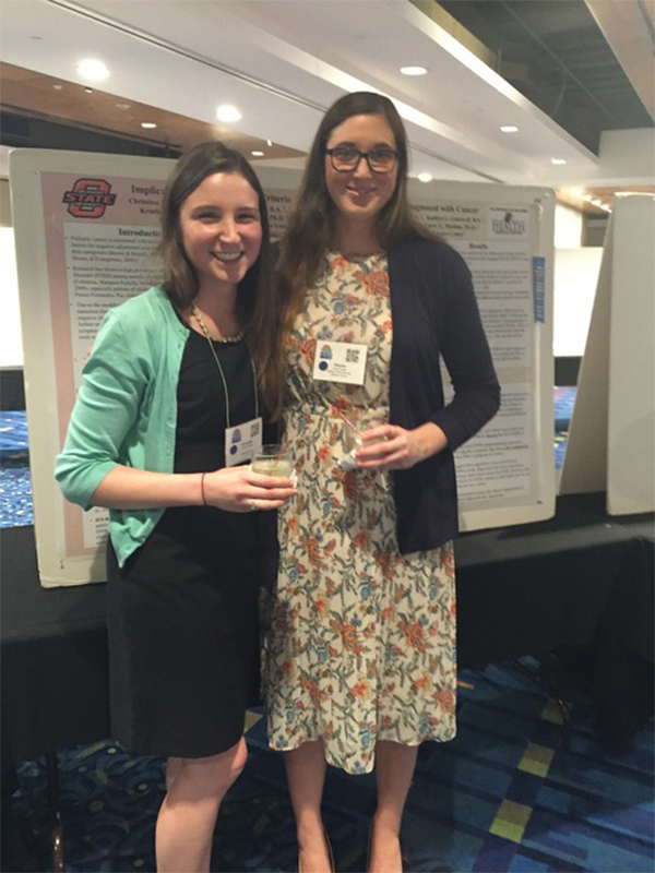Two female students in front of poster at Society of Pediatric Psychology Annual Conference