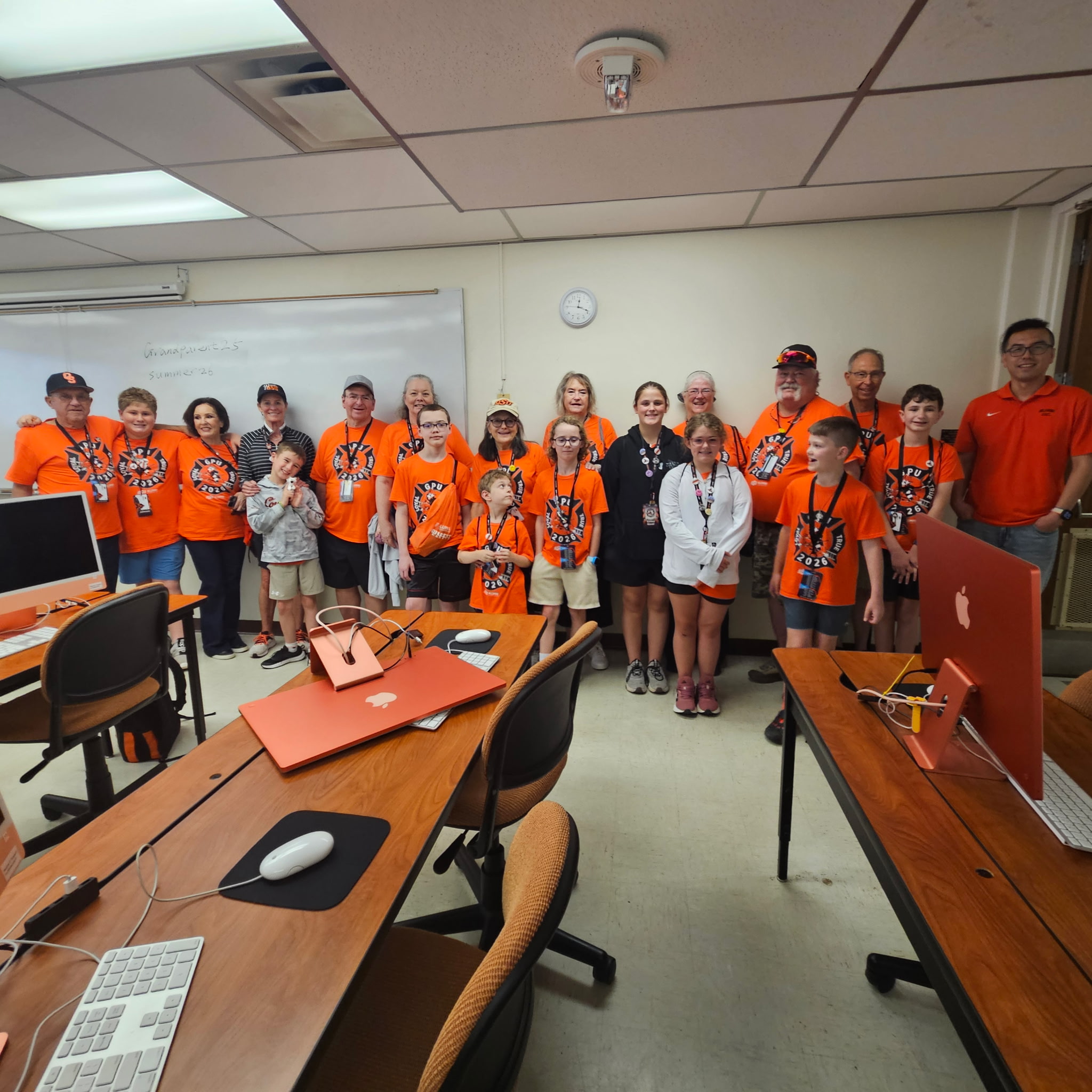 Group of students and an instructor posing together in a classroom for a group photo.