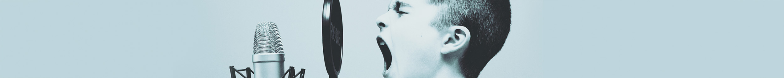 Close-up of a young man passionately yelling or singing behind a microphone, with a solid color background. Close-up of a young man passionately yelling or singing behind a microphone, with a solid color background.