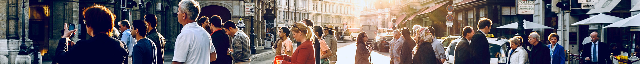 Crowded city street during daytime, with dozens of pedestrians walking in various directions past storefronts. Crowded city street during daytime, with dozens of pedestrians walking in various directions past storefronts.